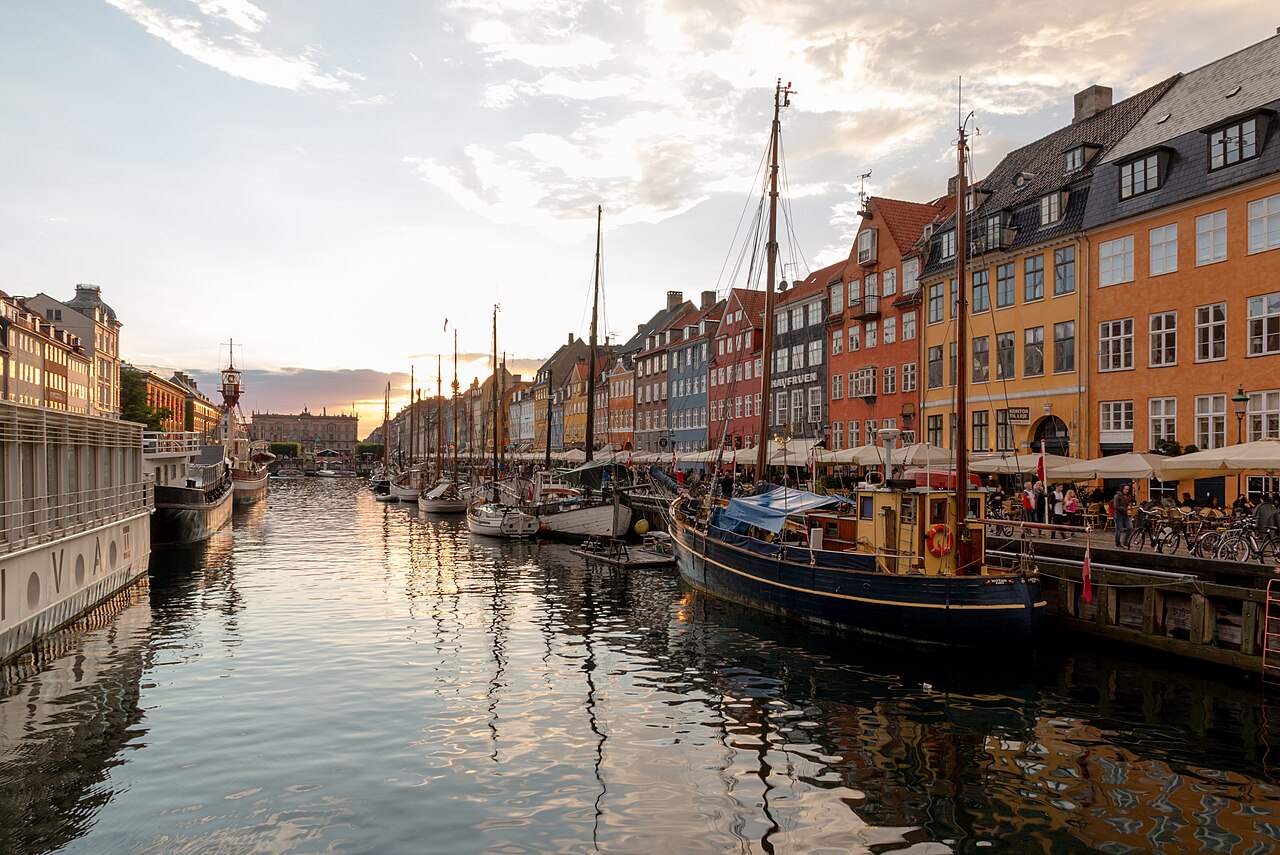 Nyhavn waterfront in Copenhagen with colorful facades and canal-side light.