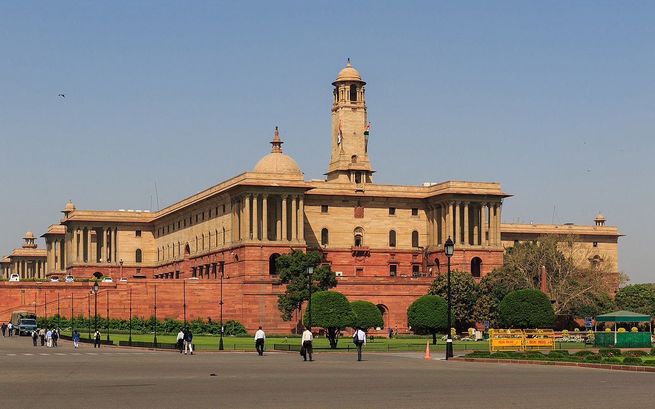 Government buildings on Rajpath in New Delhi under a wide sky.