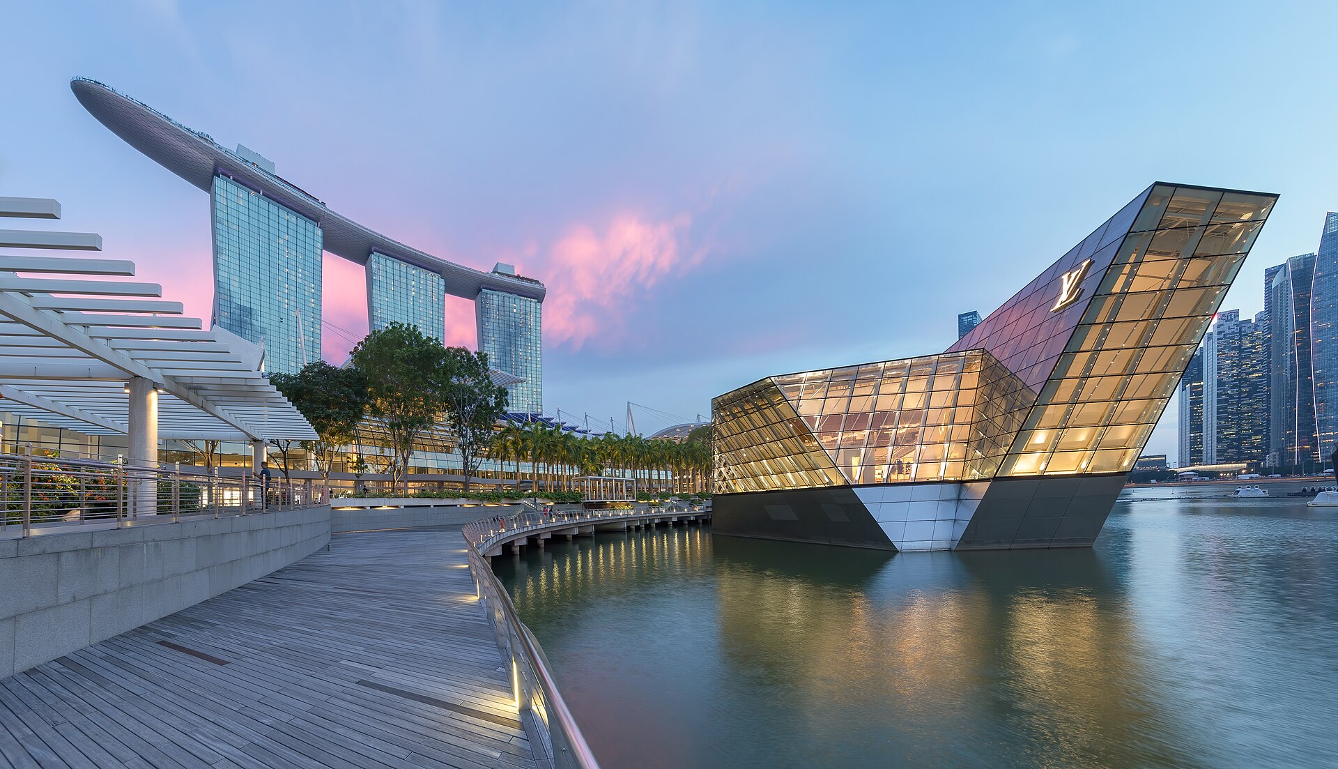 Marina Bay Sands and illuminated waterfront architecture in Singapore at blue hour.